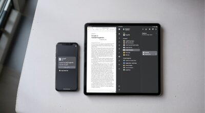 Google Pixel 10 phone and a Pixel Tablet side by side on a light grey concrete surface,