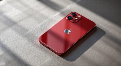 iPhone 18 Pro in Dark Cherry color resting at a slight angle on a warm grey concrete surface