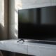A dark smart TV screen showing a blank, unresponsive browser tab, the TV resting on a